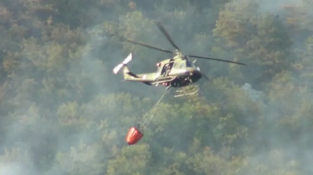 Pobočje Svete Gore je zavito v oblak dima