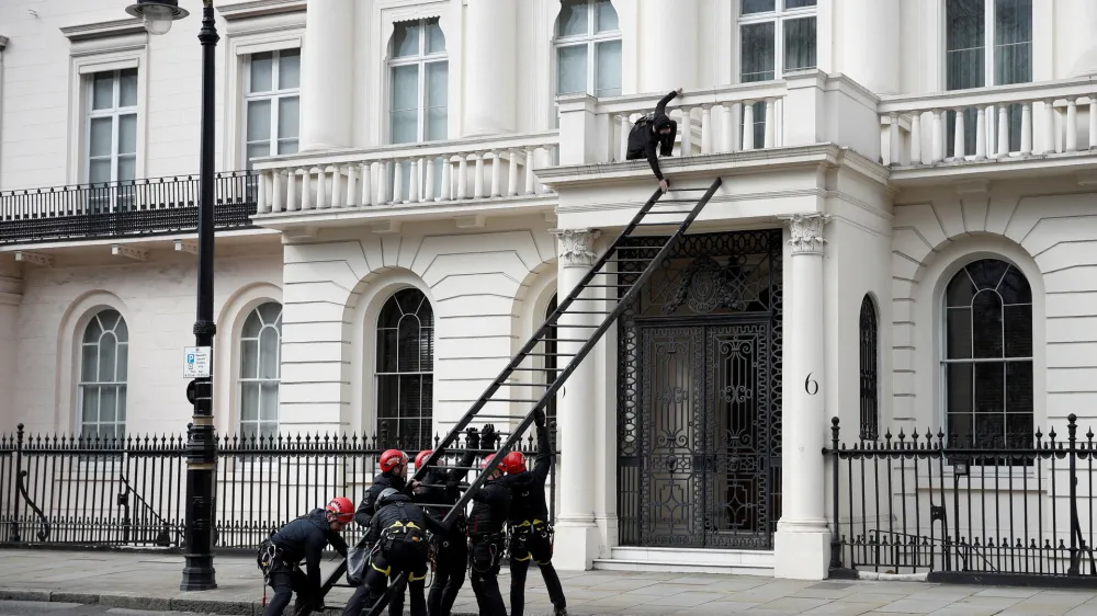 A protestor tries to push away a ladder being used by police officers as they attempt to enter a building next to the mansion reportedly belonging to Russian billionaire Oleg Deripaska, who was placed on Britain's sanctions list last week, as squatters occupy it, in Belgravia, London, Britain, March 14, 2022. REUTERS/Peter Nicholls   TPX IMAGES OF THE DAY