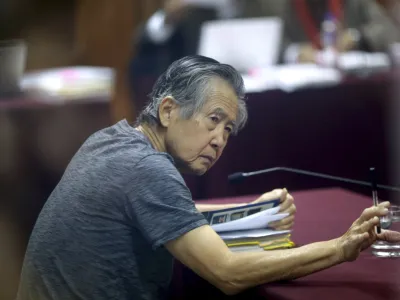 FILE - Jailed former Peruvian President Alberto Fujimori, photographed through a glass window, attends his trial at a police base on the outskirts of Lima, Peru, April 23, 2014. Peru's Constitutional Court on Thursday, March 17, 2022, approved the release from prison of Fujimori, who is serving a 25-year sentence for murder and corruption charges. (AP Photo/Martin Mejia, File)