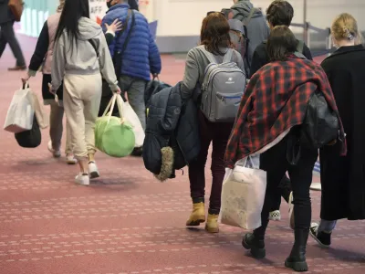 Ukrainian refugees walk upon arrival from Poland at the Haneda Airport Tuesday, April 5, 2022, in Tokyo. Japanese Foreign Minister Yoshimasa Hayashi returned from Poland on Tuesday with 20 Ukrainians displaced by Russia's ongoing war on their country as Tokyo seeks to play a greater role in international support for Ukraine. (AP Photo/Eugene Hoshiko)