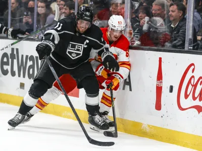 Los Angeles Kings forward Anze Kopitar (11) and Calgary Flames forward Adam Ruzicka (63) vie for the puck during the second period of an NHL hockey game Monday, April 4, 2022, in Los Angeles. (AP Photo/Ringo H.W. Chiu)