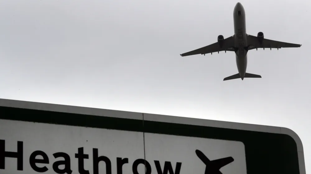 A plane takes off over a road sign near Heathrow Airport in London, Tuesday, June 5, 2018. The British Cabinet has approved the construction of a third runway at Heathrow Airport, and to put the long-running issue up for a parliamentary vote. (AP Photo/Kirsty Wigglesworth)
