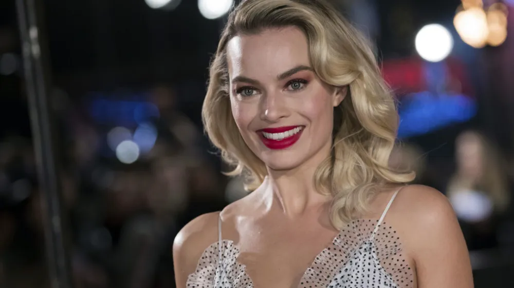 FILE - In this Monday, Dec. 10, 2018, file photo, actress Margot Robbie poses for photographers upon her arrival at the premiere of the film "Mary Queen of Scots," in London. Robbie will bring the Barbie doll to life in a live-action film. Mattel and Warner Bros. Pictures announced Tuesday, Jan. 8, 2019, that Robbie will star as the iconic doll in the franchise's first-ever live-action film. The 28-year-old "Suicide Squad" actress will also co-produce the film under her LuckyChap Entertainment banner. (Photo by Vianney Le Caer/Invision/AP, File)