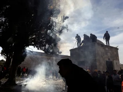 Palestinians put out a fire following a clash with Israeli security forces at the compound that houses Al-Aqsa Mosque, known to Muslims as Noble Sanctuary and to Jews as Temple Mount, in Jerusalem's Old City April 22, 2022. REUTERS/Ammar Awad   TPX IMAGES OF THE DAY