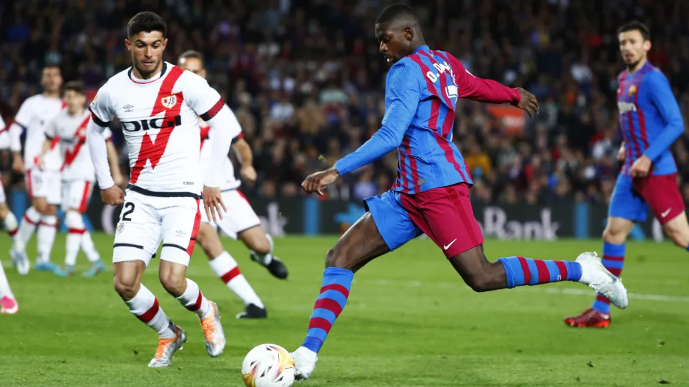 Barcelona's Ousmane Dembele, centre, shots the ball during a Spanish La Liga soccer match between FC Barcelona and Rayo Vallecano at the Camp Nou stadium in Barcelona, Spain, Sunday, April 24, 2022. (AP Photo/Joan Monfort)