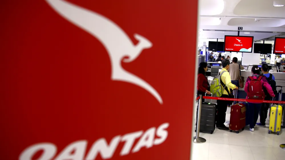 Passengers stand in line at the Qantas Airlines check-in counter in the departures area at Sydney International Airport, Australia, March 23, 2016.  REUTERS/David Gray/File Photo