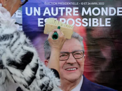 CAPTION CORRECTS THE SPELLING -Supporters of of far-left leader Jean-Luc Melenchon glue a campaign poster in Hendaye, southwestern France, Thursday, April 7, 2022. The two-round presidential election will take place on April 10 and 24, 2022. (AP Photo/Bob Edme)