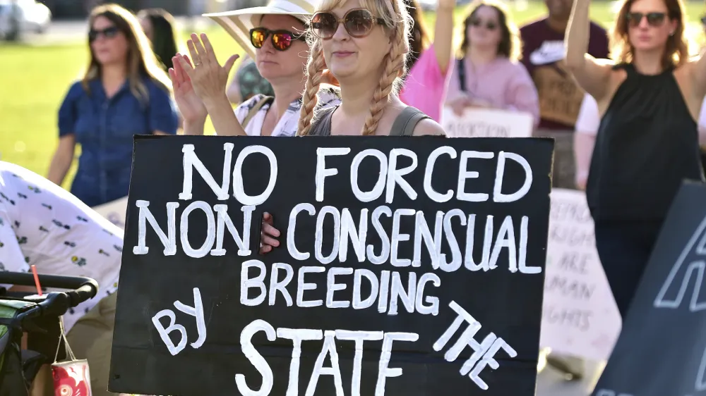 Emily Milford holds her protest sign during a rally in front of the Duval County Courthouse Wednesday, May 4, 2022 in Jacksonville, Fla. Protesters voiced their opinions after a draft opinion suggests the U.S. Supreme Court could be poised to overturn the landmark 1973 Roe v. Wade case that legalized abortion nationwide, according to a Politico report released Monday. (Bob Self/The Florida Times-Union via AP)