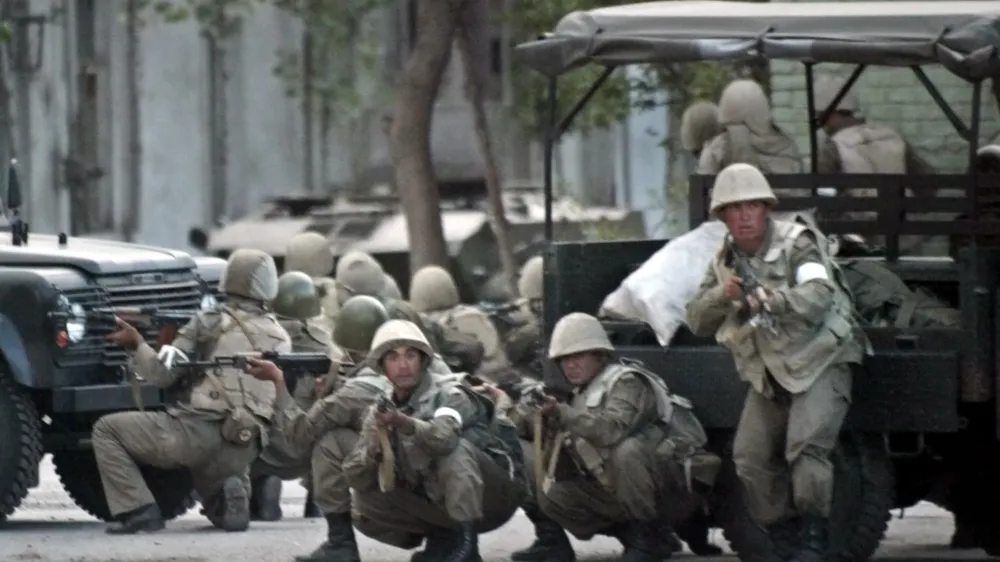 Uzbek soldiers take positions in downtown Andijan, Uzbekistan, Friday, May 13, 2005, to disperse protesters massed on the square outside the administration building. Soldiers opened fire on thousands of protesters in eastern Uzbekistan on Friday after demonstrators stormed a jail to free 23 men accused of Islamic extremism. A protest leader said about 50 people may have been killed hours earlier clashes with police and security forces. (AP Photo/Efrem Lukatsky) 