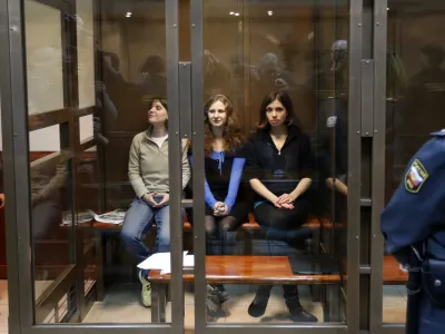 CORRECTS THE LEFTS TO RIGHT Feminist punk group Pussy Riot members, from left, Yekaterina Samutsevich, Maria Alekhina, and Nadezhda Tolokonnikova sit in a glass cage at a court room in Moscow, Wednesday. Oct. 10, 2012. Three members of the punk band Pussy Riot are set to make their case before a Russian appeals court that they should not be imprisoned for their irreverent protest against President Vladimir Putin. Their impromptu performance inside Moscow's main cathedral in February came shortly before Putin was elected to a third term. The three women were convicted in August of hooliganism motivated by religious hatred and sentenced to two years in prison. (AP Photo/Sergey Ponomarev)
