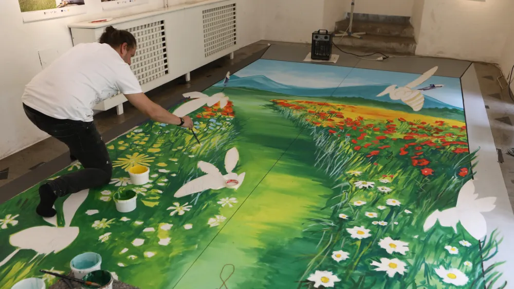 hrva&scaron;ki umetnik in Guinnessov rekorder Filip Mrvelj, - nastajanje 3D poslikave - prva anamorfna poslikava v Ljubljani -  - 18.05.2022 &ndash; Mesec čebel &ndash; razstava Čebela v Ljubljani, katera osvetljuje urbano čebelarstvo, ki se je v zadnjih letih razcvetelo v mestu, Stekleni atrij Mestne hi&scaron;e //FOTO: Luka Cjuha