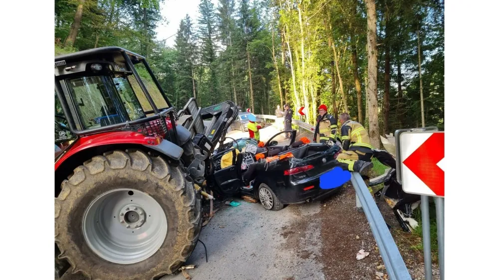 Osebni avto se je zagozdil pod traktor