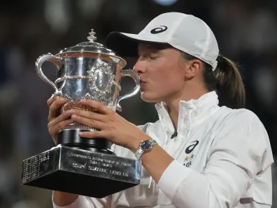 Poland's Iga Swiatek kisses the trophy after winning the final against Coco Gauff of the U.S. in two sets, 6-1, 6-3, at the French Open tennis tournament in Roland Garros stadium in Paris, France, Saturday, June 4, 2022. (AP Photo/Michel Euler)