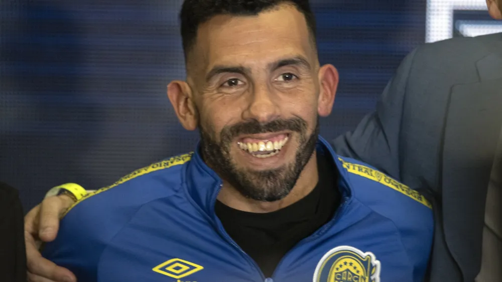 Former Boca Juniors star Carlos Tevez smiles wearing the team&acute;s jersey during his presentation as the new coach for Rosario Central, in Rosario, Argentina, Tuesday, June 21, 2022. (AP Photo/Franco Trovato)
