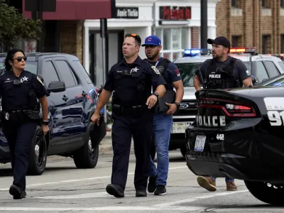 Police search the downtown area in Highland Park after a shooting at a Fourth of July parade, Monday, July 4, 2022. (AP Photo/Nam Y. Huh)