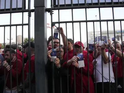 FILE - Liverpool fans wait in front of the of the Stade de France prior the Champions League final soccer match between Liverpool and Real Madrid, in Saint Denis near Paris, Saturday, May 28, 2022. A French Senate commission is releasing its initial conclusions Thursday JUNE 16, 2022 in an investigation into chaos that engulfed the Champions League final last month outside France's national stadium, including police firing pepper spray at fans and families. (AP Photo/Christophe Ena, File)