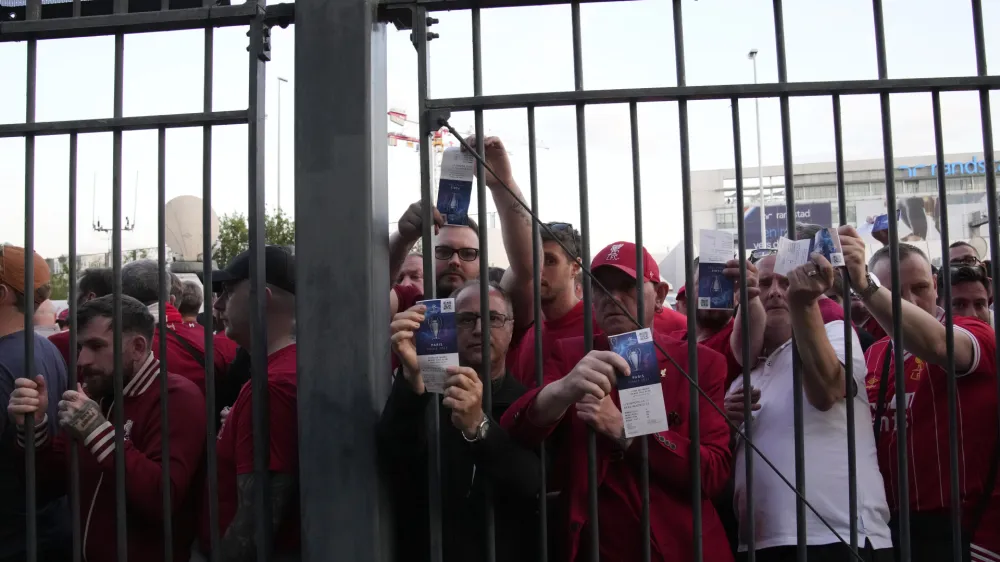 FILE - Liverpool fans wait in front of the of the Stade de France prior the Champions League final soccer match between Liverpool and Real Madrid, in Saint Denis near Paris, Saturday, May 28, 2022. A French Senate commission is releasing its initial conclusions Thursday JUNE 16, 2022 in an investigation into chaos that engulfed the Champions League final last month outside France's national stadium, including police firing pepper spray at fans and families. (AP Photo/Christophe Ena, File)