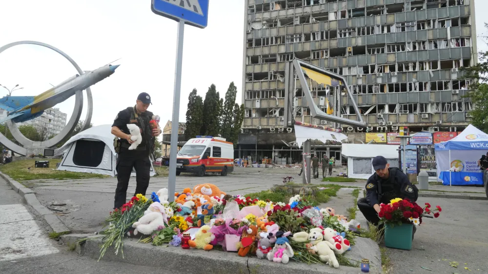 Ukrainian servicemen lay flowers at the site of a Russian shelling on Thursday, in Vinnytsia, Ukraine, Friday, July 15, 2022. Russian missiles struck the city of Vinnytsia in central Ukraine on Thursday, killing at least 23 people and injuring more than 100 others, Ukrainian officials said. (AP Photo/Efrem Lukatsky)