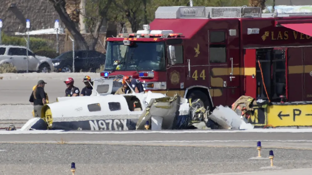 Officials investigate the wreckage of a plane at the site of a fatal crash at the North Las Vegas Airport, Sunday, July 17, 2022, in North Las Vegas, Nev. Authorities say several people are dead after two small planes collided at North Las Vegas Airport. (AP Photo/John Locher)