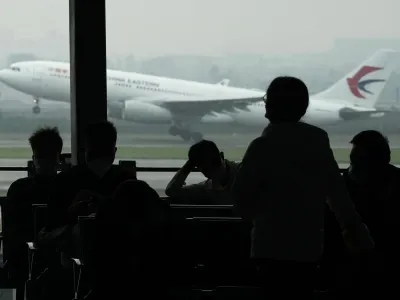 FILE - Passengers wait for their flight as a China Eastern flight takes off from the runway of Baiyun Airport on Friday, March 25, 2022, in southern China's Guangzhou province. The National Transportation Safety Board said the team departed for China on Friday, April 1, to participate in the Civil Aviation Administration of China's investigation of the March 21 crash of a China Eastern Airlines Boeing 737-800 in which all 132 people on board were killed. (AP Photo/Ng Han Guan, File)