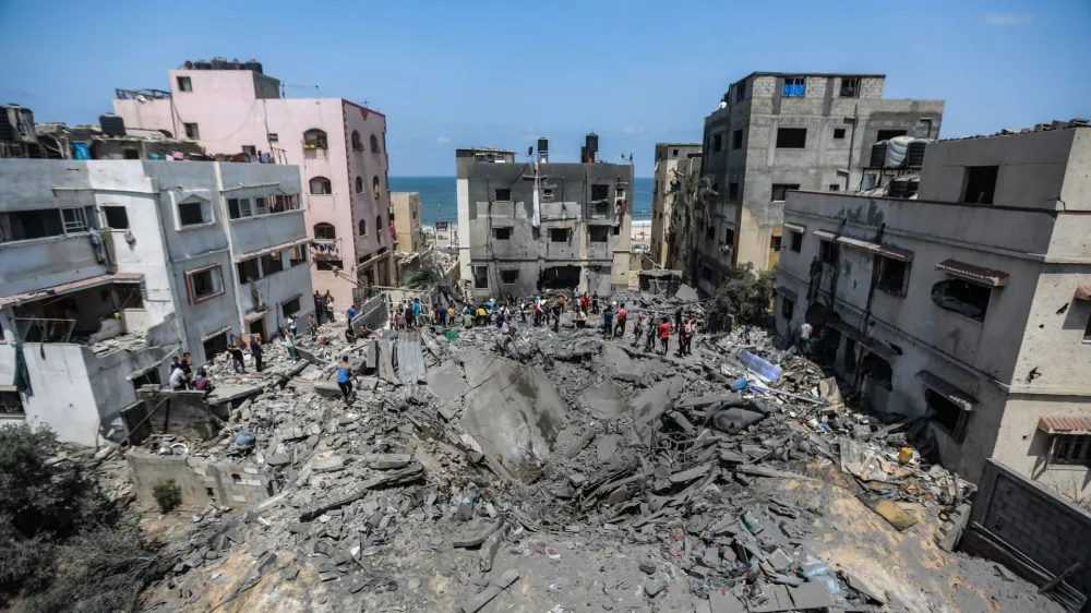 06 August 2022, Palestinian Territories, Gaza City: Palestinians inspect the ruins of a collapsed building destroyed during an Israeli air strike. The Israel Defense Forces said on Saturday they are preparing for a "week of operations" against Palestinian militants, as a barrage of retaliatory rockets were fired from Gaza overnight following the targeted killing of a Palestinian militant leader. Photo: Mohammed Talatene/dpa