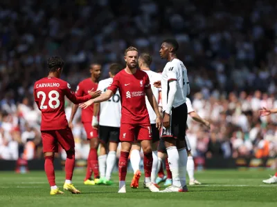 Liverpool's Fabio Carvalho, left, greets teammate Liverpool's Jordan Henderson at the end of the English Premier League soccer match between Fulham and Liverpool at Craven Cottage stadium in London, Saturday, Aug. 6, 2022. (AP Photo/Ian Walton)