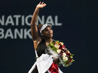 10 August 2022, Canada, Toronto: American tennis player Serena Williams (C)&nbsp;leaves the court carrying flowers and waving to fans after her defeat against Switzerland's Belinda Bencic in their women's singles round of 32 tennis match of the Canadian open. Photo: Chris Young/Canadian Press via ZUMA Press/dpa