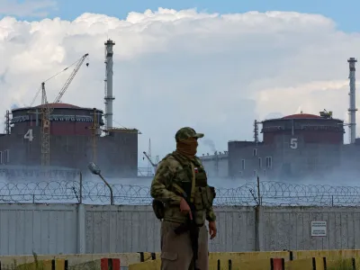 FILE PHOTO: A serviceman with a Russian flag on his uniform stands guard near the Zaporizhzhia Nuclear Power Plant in the course of Ukraine-Russia conflict outside the Russian-controlled city of Enerhodar in the Zaporizhzhia region, Ukraine August 4, 2022. REUTERS/Alexander Ermochenko/File Photo