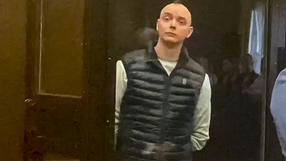 In this photo taken from video provided by the Moscow City Court, Ivan Safronov, an adviser to the director of Russia's state space corporation, right, stands in a court room prior to court session in Moscow, Russia, Monday, Sept. 5, 2022. A court in Moscow on Monday found the former journalist guilty of treason and sentenced him to 22 years in a maximum security prison, concluding a trial that has been widely seen as politically motivated. Safronov was accused of passing military secrets to Czech intelligence and information about the Russian military to a German national. The former journalist insisted on his innocence. (Moscow City Court via AP)