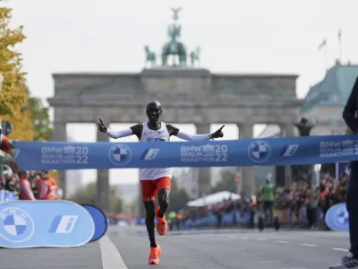 Kenya's Eliud Kipchoge crosses the line to win the Berlin Marathon in Berlin, Germany, Sunday, Sept. 25, 2022. Olympic champion Eliud Kipchoge has bettered his own world record in the Berlin Marathon. Kipchoge clocked 2:01:09 on Sunday to shave 30 seconds off his previous best-mark of 2:01:39 from the same course in 2018. (AP Photo/Christoph Soeder)