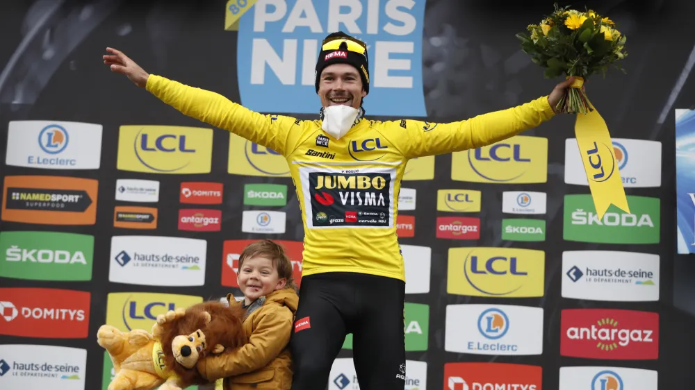 Slovenian rider Primoz Roglic of Jumbo Visma cycling team celebrates on the podium with his son Lev, after winning the Paris-Nice cycling race, in Nice, southern France, Sunday, March, 13, 2022. (AP Photo/Jean Francois Badias)