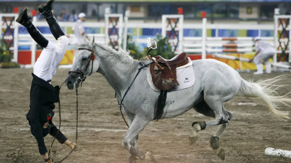 Cao Zhongrong of China falls from his horse ChuChu during the men's riding show jumping event of the modern pentathlon competition at the Beijing 2008 Olympic Games, August 21, 2008.   REUTERS/Claro Cortes IV (CHINA)