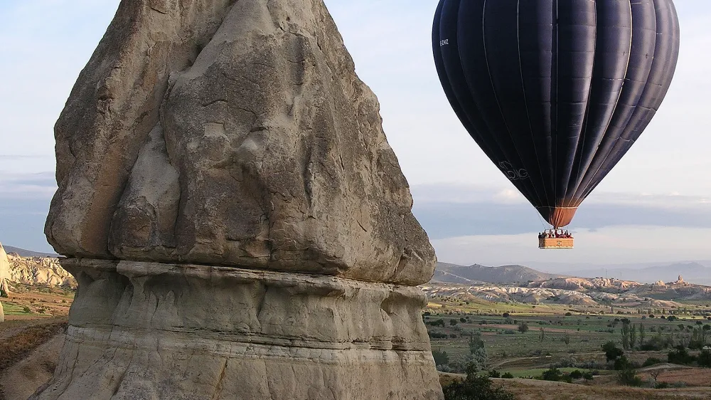 A hot air balloon rises to the sky at sunrise in Cappadocia, central Turkey, May 29, 2005. Formed by gas bubbling through ash, Cappadocia has become a favorite site for tourists in hot air balloons who can slowly drift above the "fairy chimneys" of stone that are so soft that Byzantine Greeks carved subterranean cities out of them. (AP Photo/Uzay Hacaoglu)
