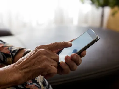 Old woman hands with mobile phone, closeup shot