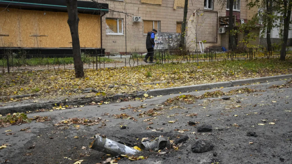 A man passes by fragments of a Russian rocket in central Bakhmut, the site of the heaviest battle against the Russian troops in the Donetsk region, Ukraine, Friday, Oct. 28, 2022. (AP Photo/Efrem Lukatsky)