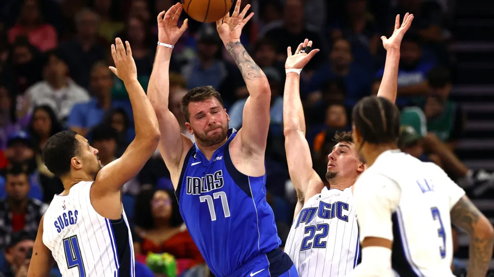 Nov 9, 2022; Orlando, Florida, USA; Dallas Mavericks guard Luka Doncic (77) drives to the basket as Orlando Magic guard Jalen Suggs (4) and forward Franz Wagner (22) defend during the second half at Amway Center. Mandatory Credit: Kim Klement-USA TODAY Sports