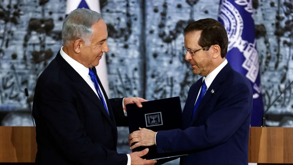 Israel President Isaac Herzog hands Benjamin Netanyahu the mandate to form a new government following the victory of the former premier's right-wing alliance in this month's election at the President's residency in Jerusalem November 13, 2022. REUTERS/Ronen Zvulun   TPX IMAGES OF THE DAY