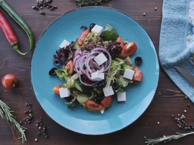 Vegan salad on wooden table decorated with spices, daylight shot