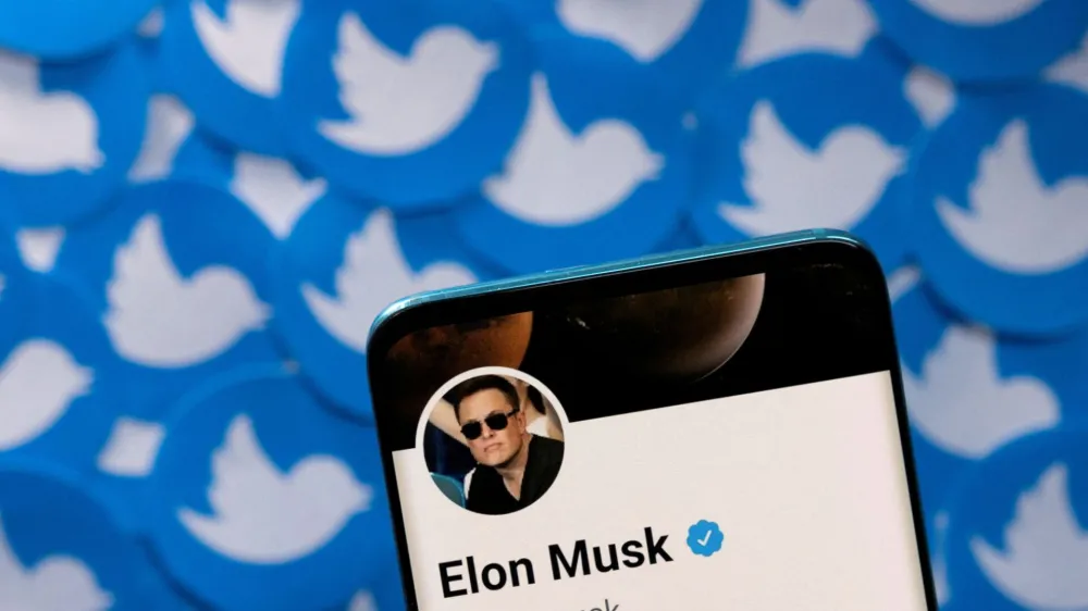 FILE PHOTO: Elon Musk's Twitter profile is seen on a smartphone placed on printed Twitter logos in this picture illustration taken April 28, 2022. REUTERS/Dado Ruvic/Illustration/File Photo/File Photo