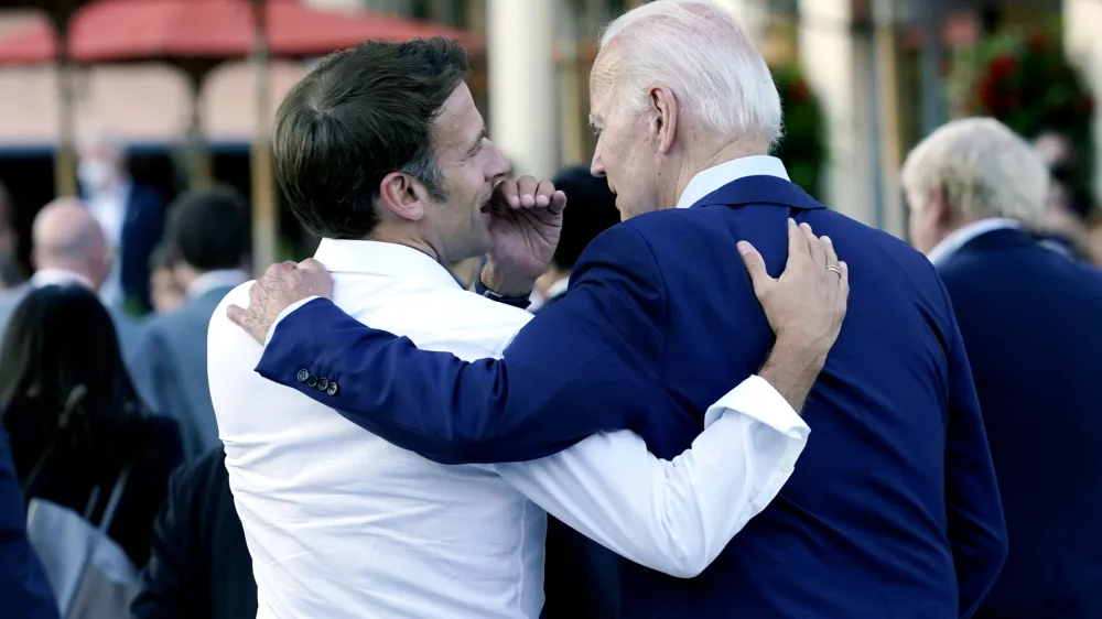FILE - French President Emmanuel Macron whispers to U.S. President Joe Biden following their dinner at the G7 Summit in Elmau, Germany, June 26, 2022. Macron is heading to Washington for the first state visit of Biden's presidency&mdash;a reviving of diplomatic pageantry that had been put on hold because of the COVID-19 pandemic. (AP Photo/Susan Walsh, File)