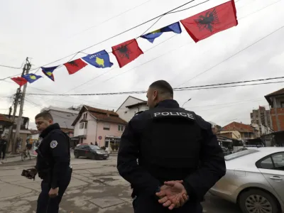Kosovo police officers guard a street in northern, Serb-dominated part of ethnically divided town of Mitrovica, Kosovo, Friday, Dec. 9, 2022. On Thursday, police increased their presence in the four ethnic Serb-dominated communes in the north, where snap election will be held Dec. 18 following the abandonment of local posts by ethnic Serb minority representatives. (AP Photo/Bojan Slavkovic)