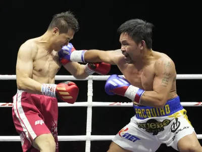 Former Filipino boxer Manny Pacquiao, right, lands his punch to South Korean martial artist D.K. Yoo during the second round of an exhibition match at the KINTEX in Goyang, South Korea, Sunday, Dec. 11, 2022. Pacquiao defeated Yoo with an unanimous decision. (AP Photo/Ahn Young-joon)