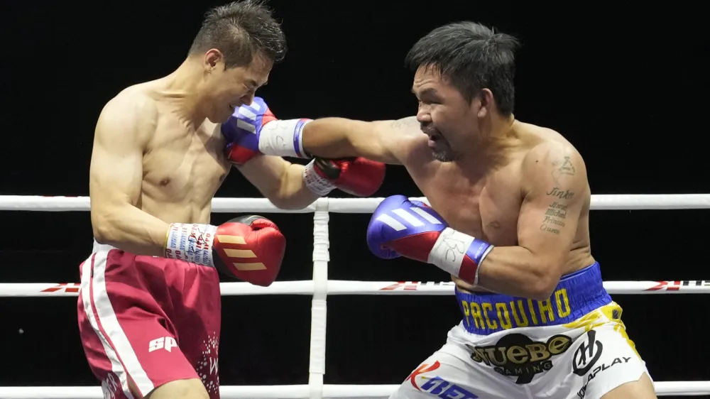Former Filipino boxer Manny Pacquiao, right, lands his punch to South Korean martial artist D.K. Yoo during the second round of an exhibition match at the KINTEX in Goyang, South Korea, Sunday, Dec. 11, 2022. Pacquiao defeated Yoo with an unanimous decision. (AP Photo/Ahn Young-joon)