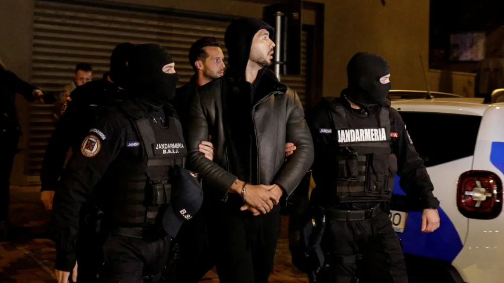 Andrew Tate and Tristan Tate are escorted by police officers outside the headquarters of the Directorate for Investigating Organized Crime and Terrorism in Bucharest (DIICOT) after being detained for 24 hours, in Bucharest,&nbsp;Romania, December 29, 2022. Inquam Photos/Octav Ganea via REUTERS ATTENTION EDITORS - THIS IMAGE WAS PROVIDED BY A THIRD PARTY. ROMANIA OUT. NO COMMERCIAL OR EDITORIAL SALES IN ROMANIA