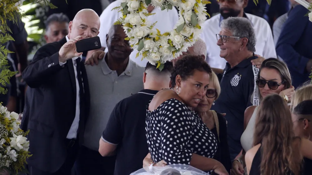 Soccer Football - Death of Brazilian soccer legend Pele - Vila Belmiro Stadium, Santos, Brazil - January 2, 2023 SENSITIVE MATERIAL. THIS IMAGE MAY OFFEND OR DISTURB FIFA president Gianni Infantino takes a selfie, and Pele's daughter, Kelly Cristina Nascimento is pictured with mourners as the body of Brazilian soccer legend Pele is seen in his casket, as he lays in state on the pitch of his former club Santos' Vila Belmiro stadium REUTERS/Diego Vara