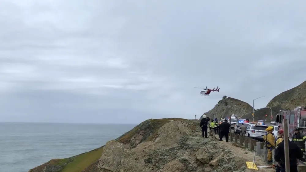 FILE - This image from video provided by Cal Fire San Mateo, Santa Cruz Unit, emergency personnel respond to the scene after a Tesla plunged off a cliff along the Pacific Coast Highway, Monday, Jan. 2, 2023, in Northern California, near an area known as Devil's Slide, leaving four people in critical condition, a fire official said. The driver of the Tesla that plunged off a cliff in Northern California, seriously wounding two children and a second adult, intentionally caused the crash and has been arrested on suspicion of attempted murder and child abuse, the California Highway Patrol said Tuesday, Jan. 3, 2023. (Cal Fire San Mateo - Santa Cruz Unit via AP, File)