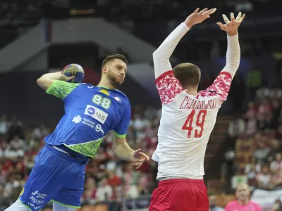 Poland's Piotr Chrapkowski, right, tries to block a shot of Slovenia's Aleks Vlah during the group B, Handball World Championship match between Poland and Slovenia in Katowice, Poland, Saturday, Jan. 14, 2023. (AP Photo/Piotr Hawalej)
