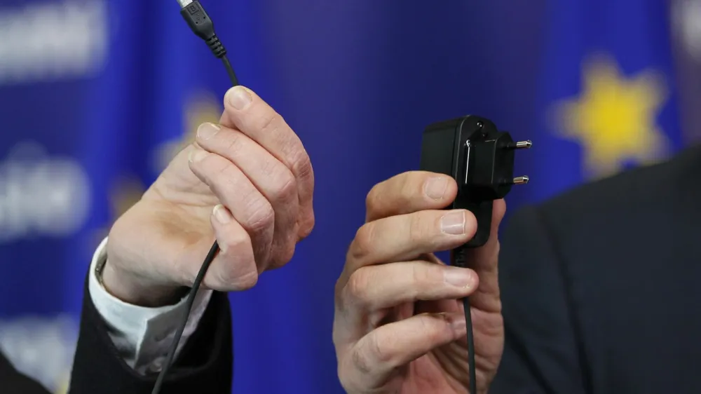 European Commissioner for Industry and Entrepreneurship Antonio Tajani and Bridget Cosgrave (L), Director General of DigitalEurope, display an harmonised mobile phone charger during a news conference at the EU Commission headquarters in Brussels February 8, 2011.  REUTERS/Francois Lenoir (BELGIUM - Tags: BUSINESS IMAGES OF THE DAY) - GM1E7281SMZ01