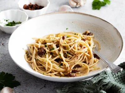 &Scaron;pageti s pečenim česnom in su&scaron;enimi paradižniki