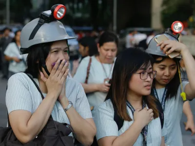 Wearing protective helmets, employees evacuate their office building following an earthquake in Manila, Philippines Monday, April 22, 2019. A strong earthquake has shaken the area around the Philippine capital, prompting thousands of people to flee to safety. There were no immediate reports of injuries or widespread damage. The U.S. Geological Survey says the magnitude 6.3 quake struck northwest of Manila near the town of Gutad on Luzon island. (AP Photo/Aaron Favila)